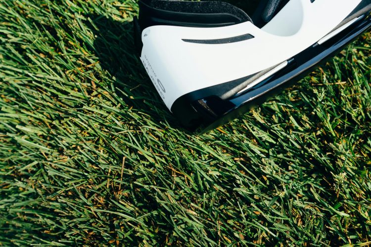 A close-up shot of VR goggles placed on a green grass lawn under sunlight.